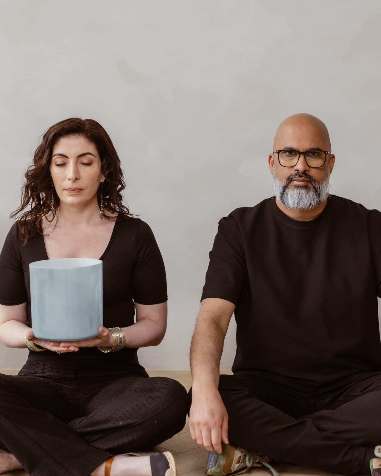 Jennifer Spencer and Steve Fernandez seated with crystal singing bowls