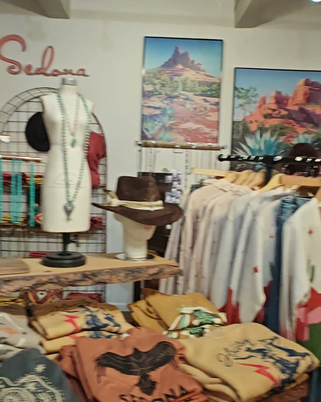 Inside a Sedona boutique on the retreat's shopping afternoon, racks of clothes under the wood ceiling