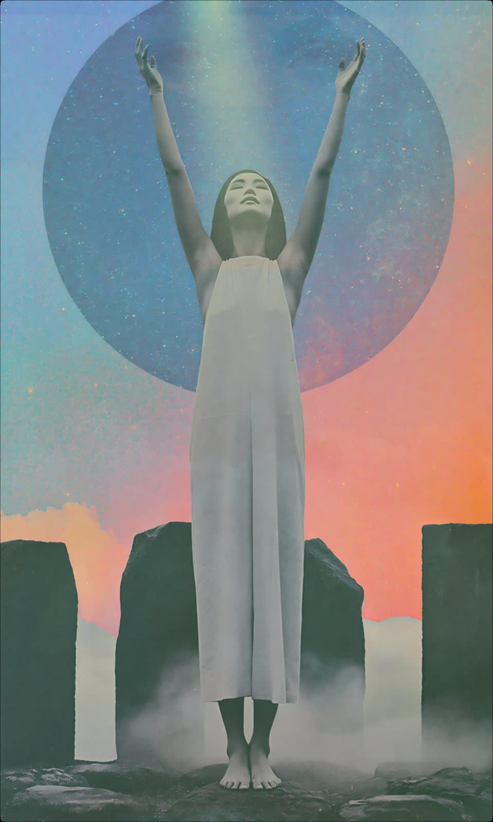 A woman in white, arms raised, in a ring of standing stones
